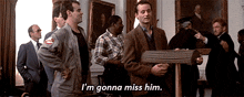 a group of men are standing in a room and one of them is saying `` i 'm gonna miss him ''