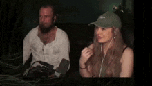 a man and a woman are playing a video game and the man is holding a controller
