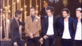 a group of men are standing next to each other in front of a stage .