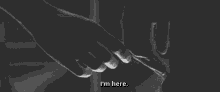 a black and white photo of a person holding another person 's hand .
