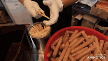 a person is putting toothpicks into a bowl of sausages and the words made in animotica are on the bottom of the screen