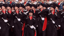 a group of soldiers are marching in a parade and one of them has a sword