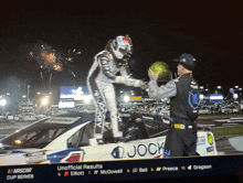 a man stands on top of a race car that says jock on it