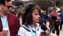 a woman in a sailor costume is talking into a microphone while standing next to a man .