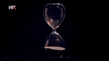 a woman 's hand is holding a hourglass with a hrt logo on the bottom