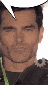 a close up of a man 's face with a speech bubble behind him