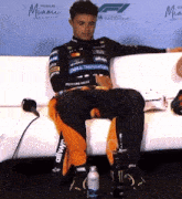 a man is sitting on a couch with a dell technology shirt on