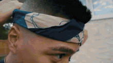 a man wearing a blue and white bandana around his head .