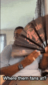 a person holding a fan with the words " where them fans at " below it