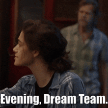 a man in a plaid shirt stands in a crowd with the words evening dream team written below him