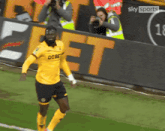 a soccer player wearing a yellow shirt that says debet