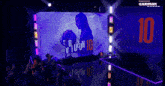 the number 10 is projected on a wall behind a crowd of people