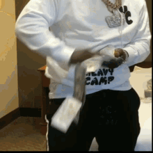 a man wearing a shirt that says heavy camp is holding money