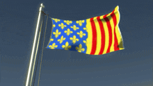 a blue yellow and red flag with fleur de lis on it is waving in the wind