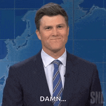 a man in a suit and tie is smiling and says damn