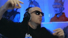 a man wearing headphones and sunglasses is dancing in front of a monkey .