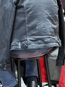 a person is sitting on a stool with their back to the camera