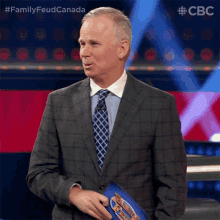 a man in a suit and tie is holding a clipboard with a picture of a car on it