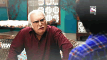 a man with glasses and a mustache is talking to another man with a sony logo on the bottom