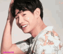 a man in a floral shirt is smiling with a watermark that says justheldek702