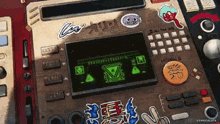 a cartoon drawing of a device with a green screen that says ' all things ' on it