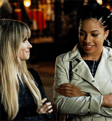 two women are standing next to each other and smiling