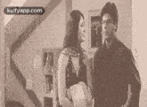 a man and woman are standing next to each other in a room .