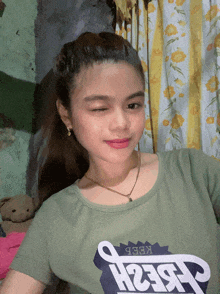 a girl wearing a green shirt with the word keep on it