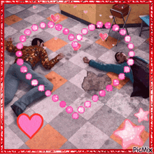 a picture of two men laying on the floor with pink hearts around them by picmix
