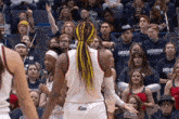 a uconn basketball player stands in front of a crowd of fans