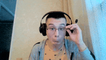 a man wearing glasses and headphones is making a face