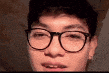 a close up of a person wearing glasses with their mouth open .