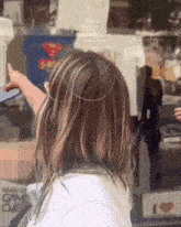 a girl is standing in front of a store window that says i love game cube