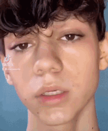 a close up of a young man 's face with a tiktok logo in the corner .