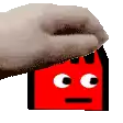a hand is holding a red cartoon character with a face on it .