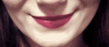 a close up of a woman 's mouth with purple lipstick .