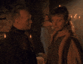 a man and a woman are standing next to each other in a dark room