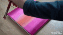 a person is painting on a pink canvas and the words made in animotica are visible