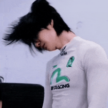 a man wearing a white shirt that says racing