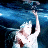 a woman with a crown on her head is reaching for something