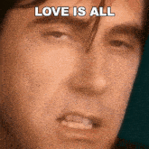 a close up of a man 's face with the words `` love is all '' written over it .