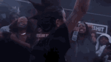 a woman with a mohawk is dancing in front of a crowd of people