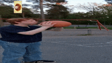 a boy in a blue shirt is throwing a football in a park