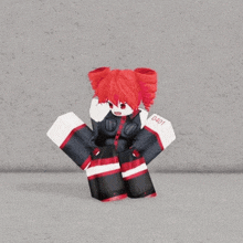 a girl with red hair is standing in front of a gray wall .