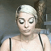 a woman with blonde hair is wearing a bra and necklace .
