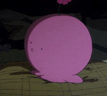 a pink cartoon character with a flower tail is laying on a bed