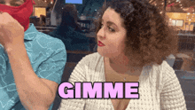 a woman says gimme in pink letters