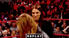 two women are wrestling in a wrestling ring in front of a crowd of people .
