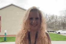 a woman with blonde hair and a lanyard around her neck that says i love