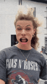 a woman wearing a guns n roses t-shirt makes a funny face